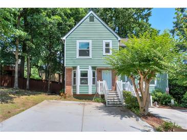 Charming two-story home with green siding, brick accents, and a welcoming front porch staircase at 5037 Laurel Springs Se Way, Smyrna, GA 30082