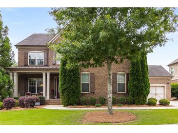Charming brick home featuring manicured lawn and meticulously maintained landscaping at 5830 Caveat Ct, Suwanee, GA 30024