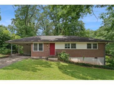 Charming brick home featuring a vibrant red door, attached carport, and mature landscaping at 4653 Ridgewood Dr, Forest Park, GA 30297