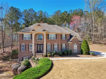 Charming two-story brick home featuring manicured landscaping and a welcoming front entrance at 5615 Toccoa Dr, Douglasville, GA 30135
