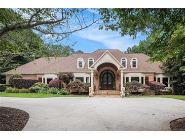 Charming brick home features a symmetrical design with a lush landscaped yard and inviting entrance at 7660 Treeridge Ct, Atlanta, GA 30350