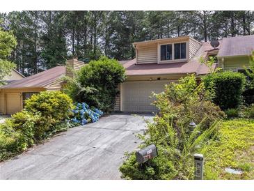 Charming townhome with a well-maintained front yard, attached garage, and driveway at 1523 Dillard Rd, Stone Mountain, GA 30088