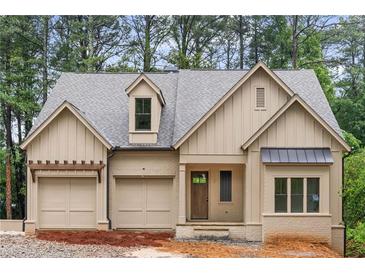 Charming, light beige, one-story home with a two car garage, covered front porch, and beautiful architectural details at 370 Chicopee Dr, Marietta, GA 30064
