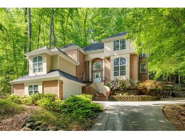 Elegant two-story home featuring brick and stucco with a lush landscaped front yard at 815 Marshview Close, Roswell, GA 30076