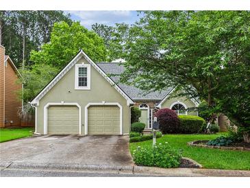 Charming exterior view of home with a two-car garage, manicured lawn, and attractive landscaping at 4710 Vineyard Se Ct, Smyrna, GA 30082