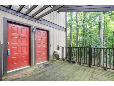 Charming condo entrance with red doors, rustic wood deck, and a view of surrounding greenery at 408 River Run Dr, Sandy Springs, GA 30350