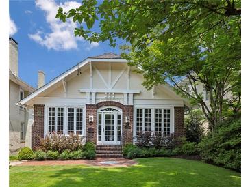 Charming brick home with a well-manicured lawn, arched entryway, and large windows at 16 Walker Ne Ter, Atlanta, GA 30309