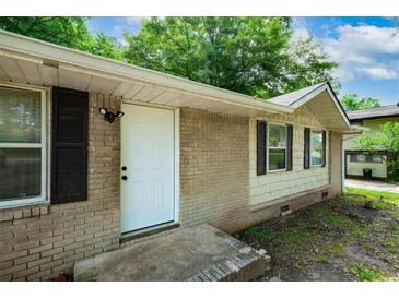 Charming single-story home featuring a brick facade, white door and black shutters and inviting curb appeal at 6516 Maddox Rd, Morrow, GA 30260