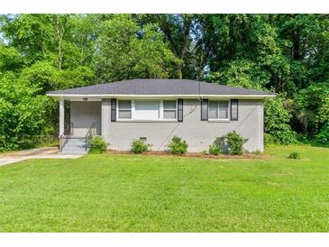 Charming gray brick home featuring a lush green lawn and manicured landscaping at 752 Jefferson Sw Ave, Atlanta, GA 30315