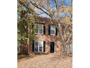 Charming two-story brick home featuring black shutters, large windows, and a front yard covered in colorful fall leaves at 687 Redland Dr # 687, Riverdale, GA 30238
