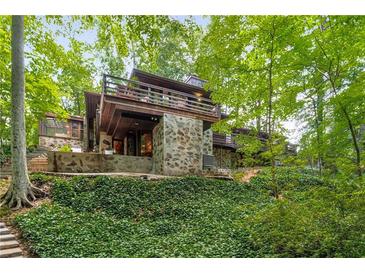 Unique home nestled in a lush, wooded setting offers privacy and scenic views from the upper level deck at 2016 Castleway Ne Dr, Atlanta, GA 30345