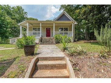 Charming home with a welcoming porch, landscaped front yard, and inviting red front door at 58 Bisbee Se Ave, Atlanta, GA 30315