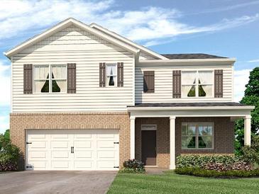 Charming two-story home featuring white siding, brick accents, and a two-car garage at 8215 Coldstream Dr, Fairburn, GA 30213