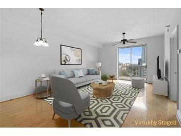 Inviting living room with modern decor, stylish furnishings, and a balcony overlooking the city at 285 Centennial Olympic Park Nw Dr # 1407, Atlanta, GA 30313