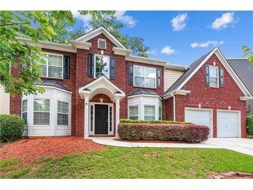 Charming two-story brick home featuring a well-manicured lawn and symmetrical design at 3065 Moser Way, Marietta, GA 30060