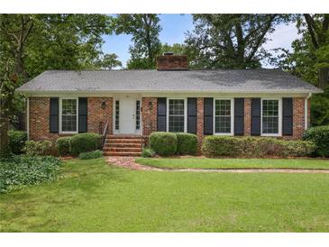 Charming brick home with manicured lawn, black shutters, and brick steps to the front door at 59 Oakmont Nw Dr, Marietta, GA 30064