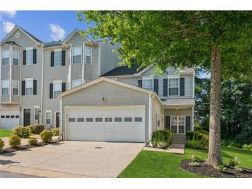 Attractive townhome featuring a two-car garage, classic siding, and landscaped front yard at 1714 Indian Way, Cumming, GA 30040