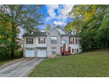 Charming two-story home featuring a brick facade, red shutters, and a well-manicured front lawn at 9444 Lakeview Ct, Douglasville, GA 30135