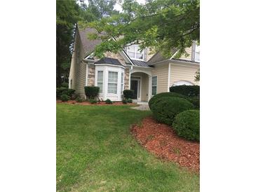 Charming home boasts a well-manicured lawn and neatly trimmed bushes, creating a welcoming curb appeal at 1697 Preserve Park Dr, Loganville, GA 30052