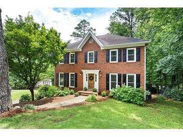 Traditional brick home with black shutters and a well-manicured lawn at 4522 Reva Ne Ct, Marietta, GA 30066