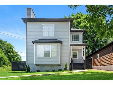 Charming two-story home with gray siding, black trim, and a well-manicured lawn in a desirable neighborhood at 900 Ira Sw St, Atlanta, GA 30310