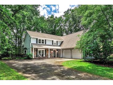 Charming two-story home with a well-manicured lawn and mature trees, creating a serene and inviting curb appeal at 270 Hollyridge Way, Roswell, GA 30076