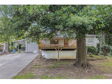 Charming home featuring a large wooden deck and an ample-sized front yard surrounded by lush trees at 726 Alfred Nw Rd, Atlanta, GA 30331