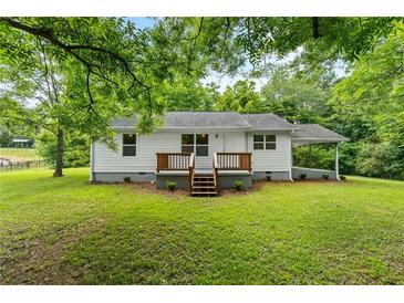Charming home featuring a well-maintained lawn, inviting entryway, and a classic carport offering a welcoming curb appeal at 1179 Chatham Rd, Buford, GA 30518