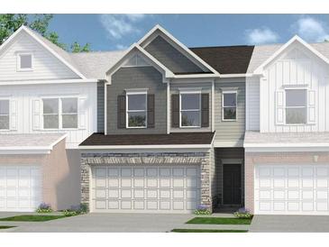 Charming townhome featuring a two-car garage, stone accents, and a mix of gray and white siding at 2490 Ravencliff Dr # 150, Austell, GA 30168