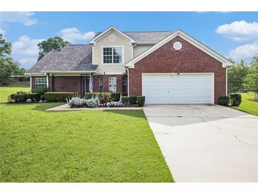 Charming two-story brick home with a well-manicured lawn and a two-car garage on a sunny day at 1698 Bennett Dr, Mcdonough, GA 30253