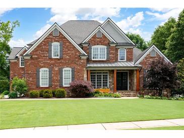 Charming red brick home with a well-manicured lawn, gray shutters, and a welcoming front porch at 2260 Falkirk Pointe Dr, Marietta, GA 30062