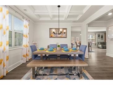 Bright dining room featuring a decorative ceiling, stylish lighting, and a wooden table with bench seating at 372 Garnet Dr, Acworth, GA 30101