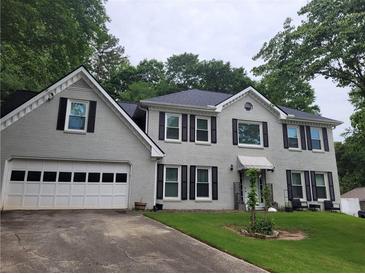 Charming two-story home with gray painted brick, black shutters, and a well-manicured lawn at 4635 Tims Pl, Snellville, GA 30039
