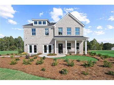 Stunning two-story brick home with covered porch, manicured lawn, and beautiful landscaping at 6106 Marigold Way, Atlanta, GA 30349