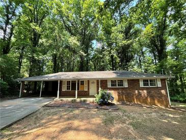 Charming brick home with a covered carport and lush green surroundings at 6106 Oak Hill Sw Dr, Austell, GA 30168