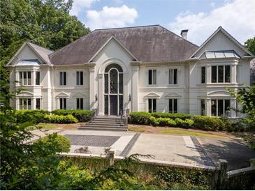 Elegant two-story home with a grand entrance, manicured landscaping, and a circular driveway at 70 Finch Forest Trl, Atlanta, GA 30327