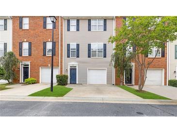 Charming townhome with brick and gray siding, featuring a one-car garage and well-maintained landscaping at 5357 Beaver Br, Norcross, GA 30071