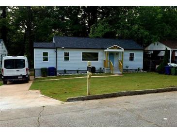 Charming home featuring a newly-mowed lawn, fresh paint, and a bright blue front door at 1227 Kenilworth Dr, Atlanta, GA 30310