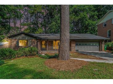 Charming brick home with a well-maintained lawn and an attached two-car garage at 1260 Fork Creek Trl, Decatur, GA 30033