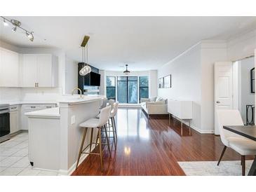 Bright living room features hardwood floors, a breakfast bar, and large windows at 400 17Th Street Nw # 2313, Atlanta, GA 30363