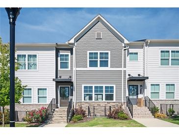 Charming townhome featuring stone accents, landscaped yard, and a welcoming entrance, perfect for modern living at 1947 Drew Nw Dr, Atlanta, GA 30318