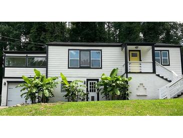 Charming home with a striking black and white exterior, highlighted by vibrant banana trees in the front yard at 2170 Beecher Sw Cir, Atlanta, GA 30311