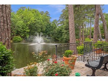 A serene pond view with a central fountain, lush trees, flowers and benches create a park-like atmosphere at 26303 Plantation Ne Dr # 303, Atlanta, GA 30324