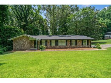 Charming brick ranch-style home with well-maintained lawn and mature trees at 2173 Tanglewood Ne Trl, Conyers, GA 30013