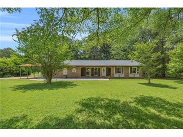 Charming single-story brick home with a well-maintained lawn and mature trees at 676 Smith Store Rd, Covington, GA 30016