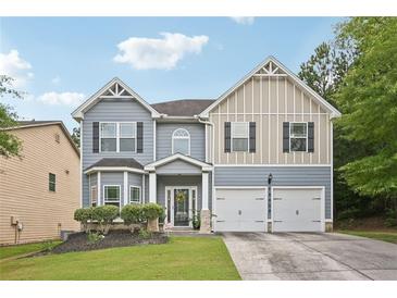 Charming two-story home with a two-car garage, well-maintained lawn, and inviting curb appeal at 7530 Springbox Dr, Fairburn, GA 30213