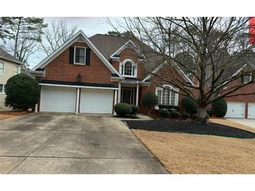 Charming two-story brick home with a well-manicured lawn and a two-car garage in a suburban neighborhood at 2612 Peterboro Row, Marietta, GA 30062
