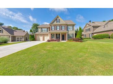 Charming two-story home with lush green lawn, three-car garage and a basketball hoop on the driveway at 456 Rockford Sw Pass, Marietta, GA 30064