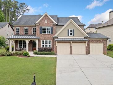 Traditional brick home with a three-car garage, landscaped yard, and covered front porch at 508 Highland Drive Dr, Woodstock, GA 30188