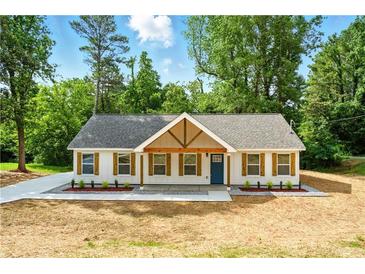 Charming home with a blue front door and wooden shuttered windows framed by lush greenery at 38 Creek Se Dr, Cartersville, GA 30121